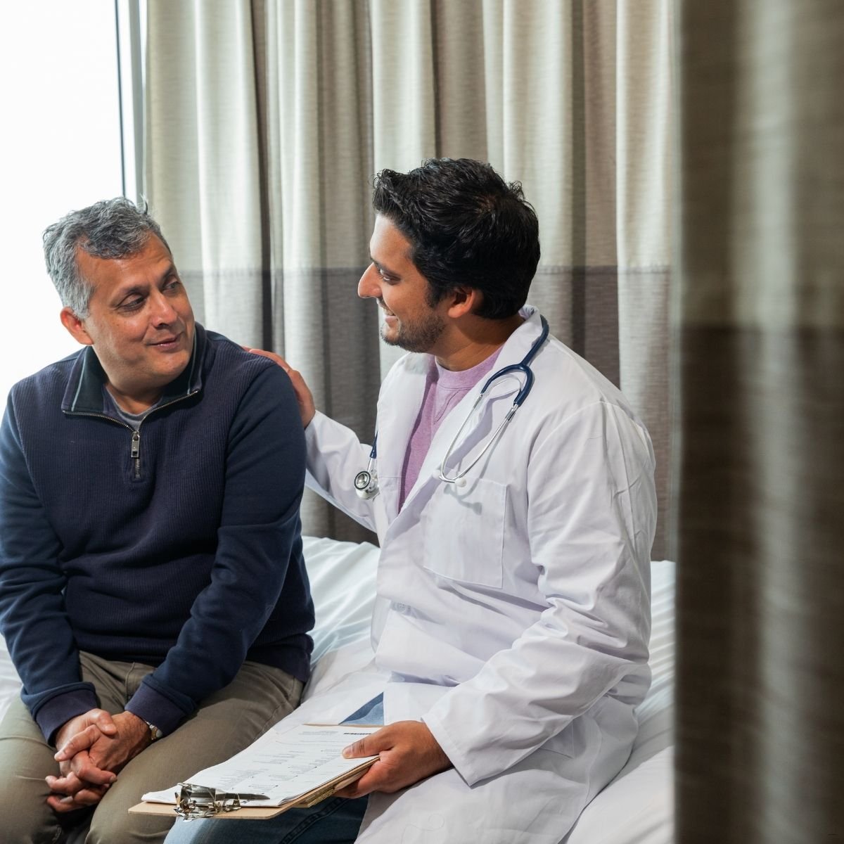 consulta com geriatra - idoso ao lado de um médico em uma consulta